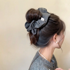 Dark grey starburst rhinestone scrunchie for women shown in a stylish ponytail hairstyle