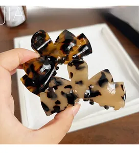 Macro detail of tortoiseshell acetate bow hair claws with durable metal springs