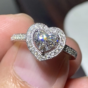 Macro view of heart-shaped halo engagement ring with pavé diamonds in white gold