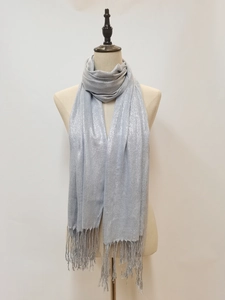 Detail of silver grey shimmering scarf with fringe tassels on a fashion mannequin