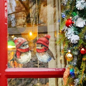 Christmas window decals featuring cute birds in winter hats on glass with holiday background