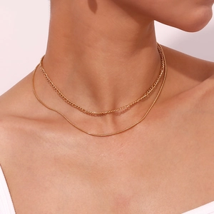 Close-up of layered 18K gold-plated Figaro and snake chain necklace on model