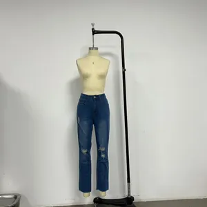 Gros plan sur un jean bleu foncé taille haute avec détails déchirés et délavés au genou