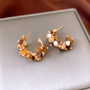 18K gold plated flower earrings with tiger eye stone and white pearls on silk background