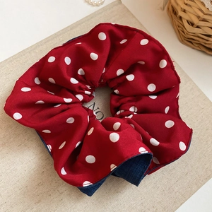 Detailed view of red polka dot hair scrunchie with blue denim fabric lining