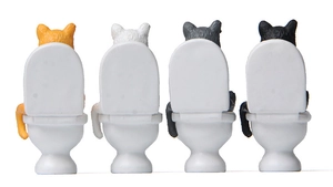 Rear view of four miniature cats sitting on toilets for creative garden landscaping