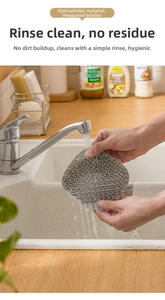 Close-up of grey silicone kitchen cleaning brush being rinsed under running water