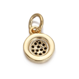 Macro view of gold round charm with black dot pattern for DIY jewelry making