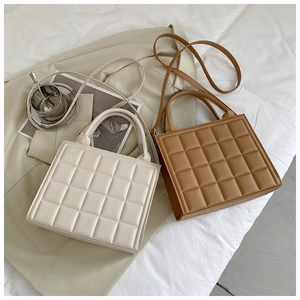 Quilted crossbody bag shown in beige and tan colors on a stylish minimalist lifestyle setting