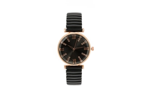 Close-up of black dial watch with rose gold Roman numerals and elastic band