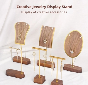 Detail of walnut wood and gold metal jewelry display stands for necklaces and earrings