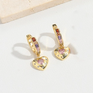 Detail of heart-shaped colorful zircon earrings with gold finish on a stone display