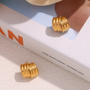 Macro detail of gold plated 18K stainless steel layered earrings with vertical stripes