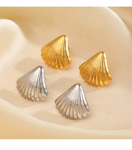 Detailed view of gold and silver shell-shaped stud earrings on soft silk fabric