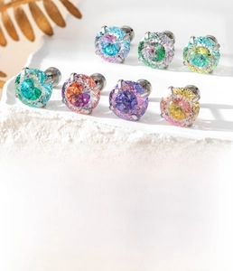 Macro detail of gradient zircon titanium steel studs showing 6mm and 8mm sizes