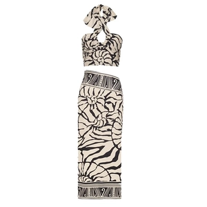 Detail view of two-piece halter top and long skirt with black and white tropical print