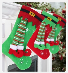 Close-up of four felt Christmas stockings with 3D elf legs hanging on a fireplace mantel