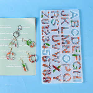Makroansicht der Harzformen für Buchstaben mit Trockenblumen für DIY-Schmuckherstellung