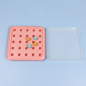 Detailed view of pink silicone ice ball mold with a clear lid and small colored balls