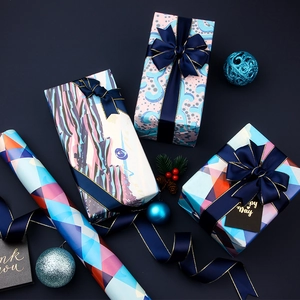 Blue gift wrapping paper set with ribbons and tags featuring geometric wave patterns