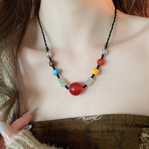 Detail of bohemian necklace with multi-colored stone beads on a black woven cord