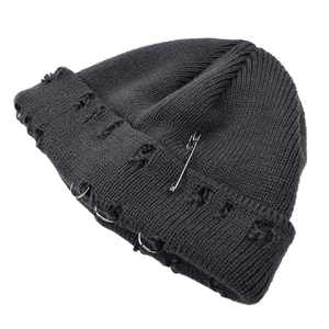 Detailed view of dark grey distressed knit beanie with silver rings and safety pin