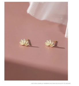 Macro detail of elegant golden lotus stud earrings with a high-quality mirror silver finish