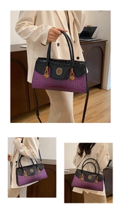 Detail of retro purple and black crocodile pattern handbag with gold hardware