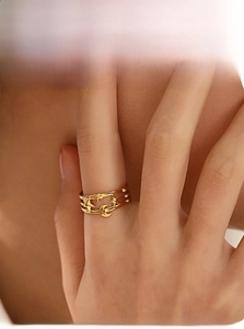 Detailed view of a gold celestial ring featuring hollow star and moon patterns on finger