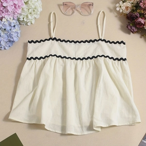Detail des cremefarbenen Camisole-Tops mit schwarzem Wellensaum und Strukturstoff