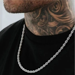 Close-up of silver twist chain necklace worn by a male model with tattoos