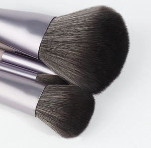 Macro detail of soft gradient bristles and lilac matte metal ferrules on makeup brushes
