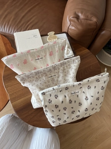 Floral cotton makeup bags with zippers and simple wish labels on a wooden tray