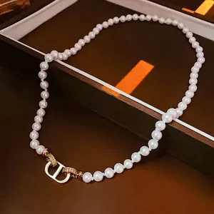 Vue détaillée du fermoir CD entrelacé plaqué or 18k serti de cristaux sur perles
