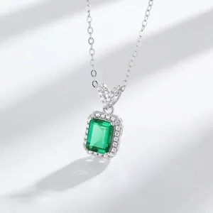 Macro shot of an emerald-cut green pendant with brilliant white diamond halo setting