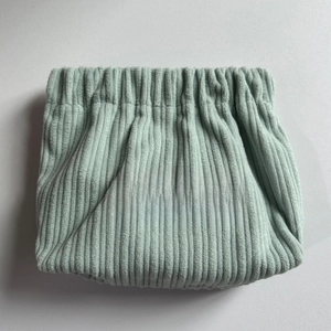 Detail shot of light green corduroy storage pouch with a Free Travel label
