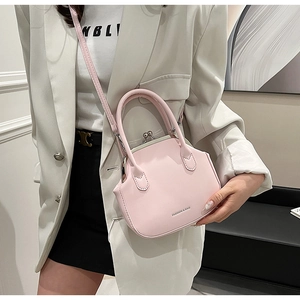 Detail of light pink retro satchel featuring metal frame closure and top handles