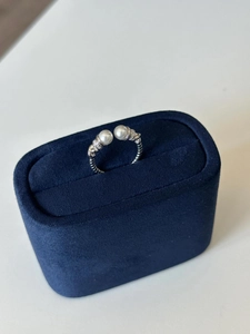 Macro shot of silver pearl twist ring in velvet box with sparkling zircon details