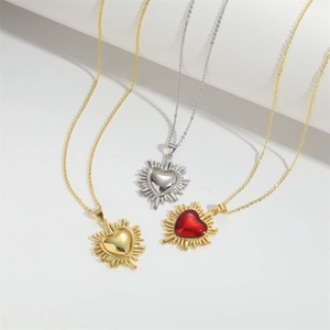 Vintage heart necklaces in gold, silver, and red gemstone with radiant sunburst pattern