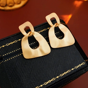 Detailed shot of gold irregular geometric hollow earrings with a matte metallic finish