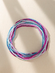 Detailed macro view of colorful Bohemian waist beads in vibrant blue and pink tones