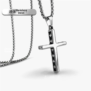 Close-up of stainless steel cross pendant necklace with black inlay and pearl chain link