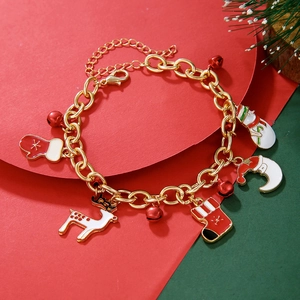 Close-up of Christmas charm bracelet with reindeer and snowman charms on festive background