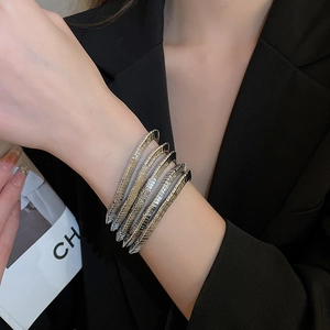 Detail view of multi-layer metallic wrap bracelet with gold and silver snake chain spirals
