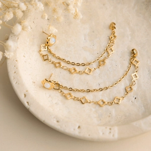 Dettaglio orecchini a fiore in oro 18K con pietra opale e nappe a catena lunga ed elegante