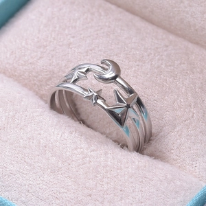 Macro detail of silver celestial ring with crescent moon and star motifs in jewelry box