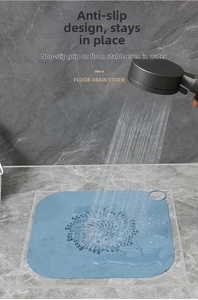 Filtro raccogli capelli in silicone blu con fori di drenaggio su piastrelle grigie