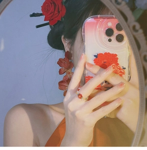 Detailed view of red rose earrings and beaded ring in a retro Chinese aesthetic