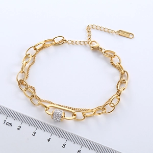 Golden stainless steel dual chain bracelet with micro-paved crystal beads shown with ruler