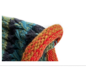 Close-up of multicolor chunky knit texture with orange, blue, and green woven patterns